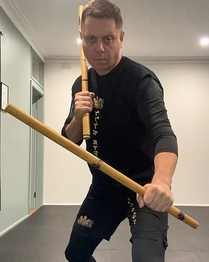 Senior Master Giovanni Zagari holding a rattan stick in a ready stance during Kali 3D training
